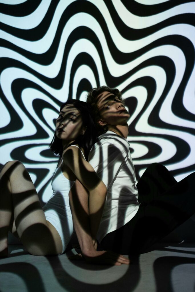 pexels-photo-6492155-6492155 Artistic photo featuring two people with a trippy, psychedelic pattern projection.